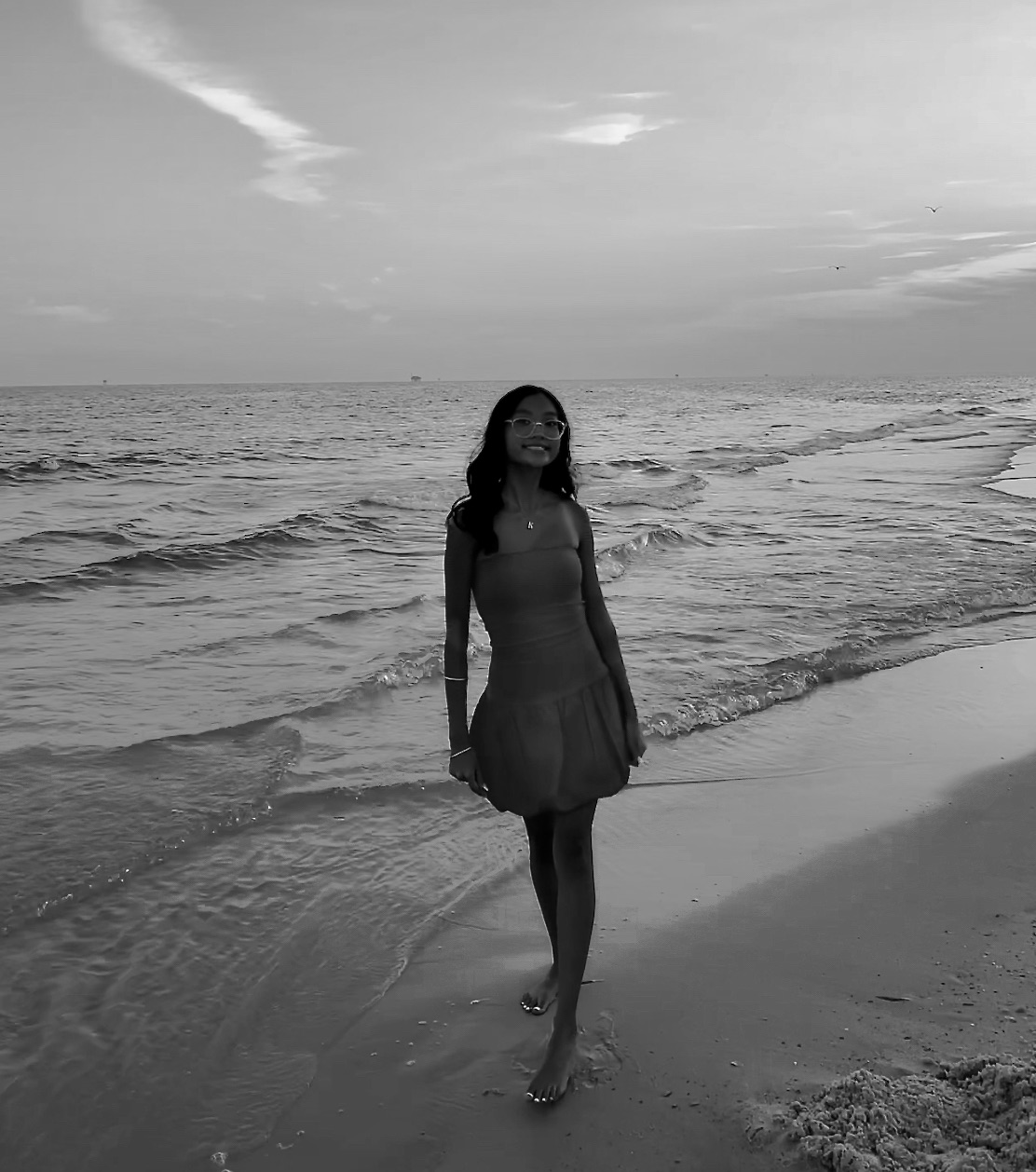 Kaylie walking along the beach in black and white